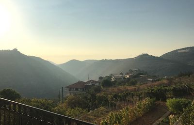 Scenic view of mountains and houses against sky