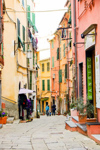 People walking on footpath amidst buildings in city