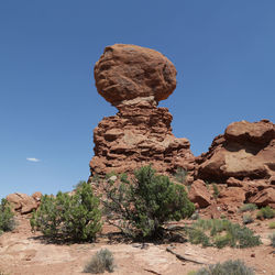 Low angle view of rock formation against clear blue sky