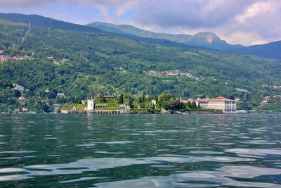 Scenic view of lake by buildings against sky