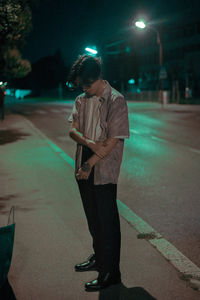 Full length of man standing on road at night