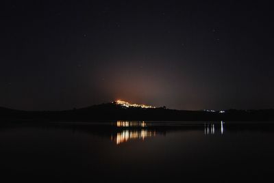 Scenic view of lake against sky at night