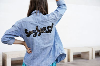 Rear view of woman with text on denim shirt