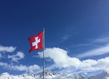 Low angle view of flag against blue sky