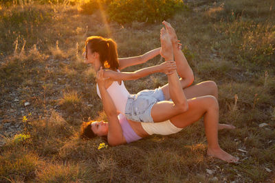 Side view of woman sitting on grassy field
