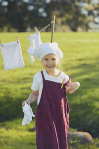 Portrait of smiling young woman standing on field