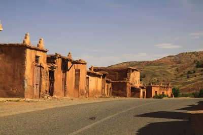 Old building by road against sky