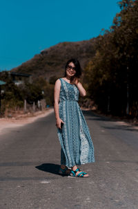 Portrait of smiling young woman standing on road