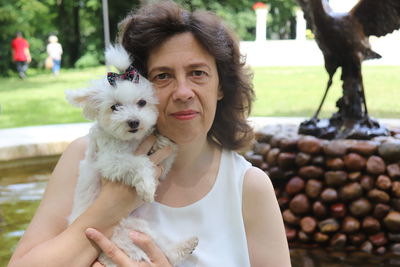 Portrait of mature woman with puppy at park