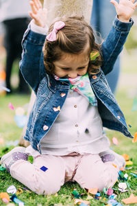 Cute girl playing with confetti on field