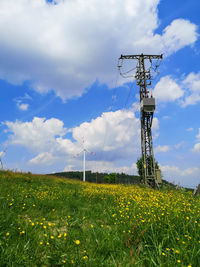 Wind turbines on field against sky