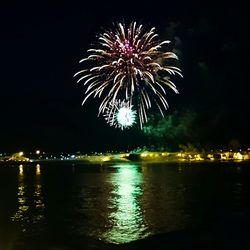 Firework display over river at night