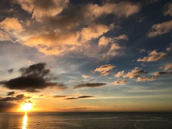 Scenic view of sea against dramatic sky during sunset