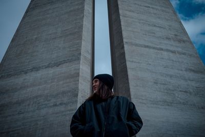 Low angle view of woman standing against wall