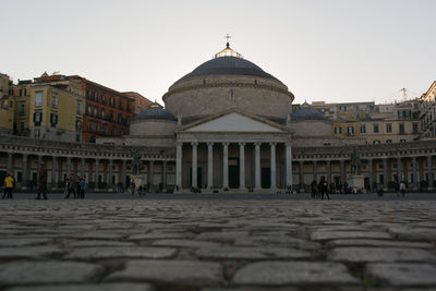 Group of people in front of building against clear sky