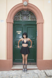 Full length of woman standing at entrance of building