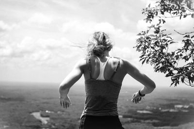 Rear view of woman standing against landscape