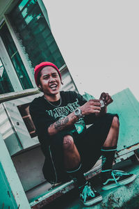 Portrait of smiling man holding while sitting outdoors