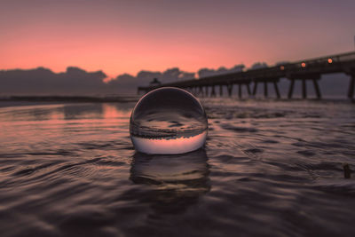 Reflection of calm sea in transparent ball