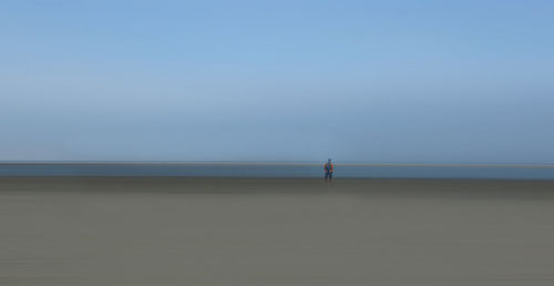 Man standing on beach against clear sky