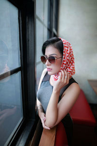 Portrait of young woman wearing sunglasses while sitting in car