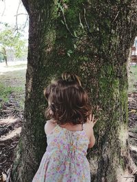 Girl standing on tree trunk