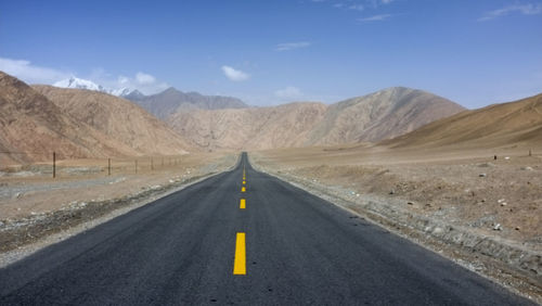 A flat new unmanned road leads to the snowy mountains ahead