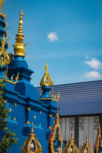 Low angle view of sculpture and building against sky