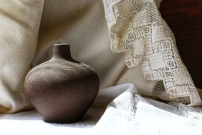 Close-up of earthenware against white textile