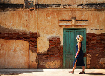 Woman standing against brick wall