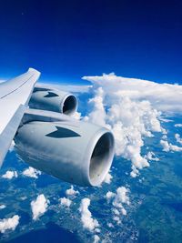 View of airplane wing against clouds