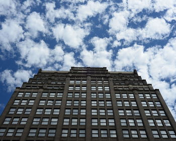 Low angle view of helmsley organization against cloudy sky in city