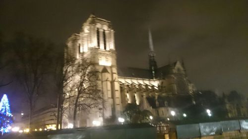 Low angle view of clock tower at night