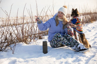 Full length of woman standing on snow covered field