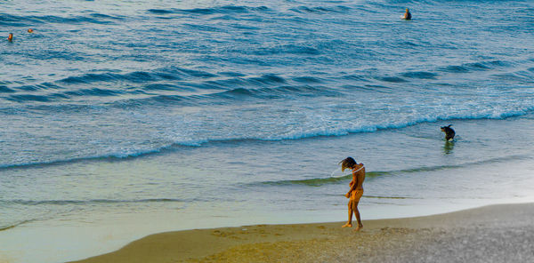 Full length of shirtless man walking on beach