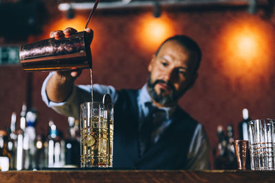 Bartender making drink at counter