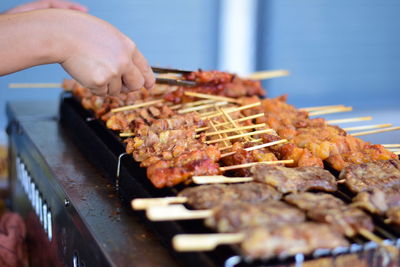 Person preparing food on barbecue grill