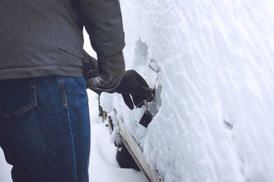 Midsection of man opening car door during winter