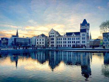 Reflection of buildings in water at sunset