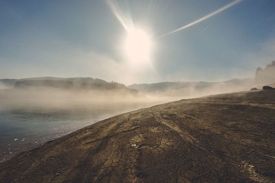 Scenic view of land against sky on sunny day