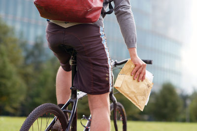 Midsection of man riding bicycle in city