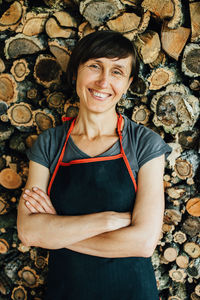 Portrait of female woodworker looking at camera and smiling, close up