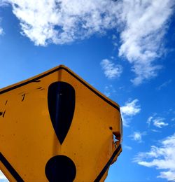 Low angle view of road sign against blue sky