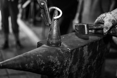 Cropped hand of person working with anvil