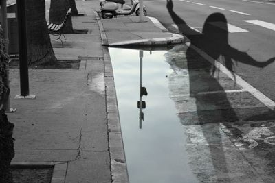 Reflection of people on puddle in city street