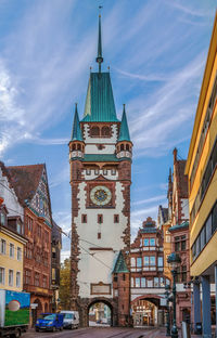 Buildings in city against cloudy sky