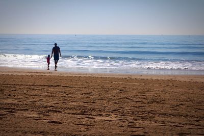 Full length of woman on beach against sky