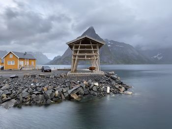 Scenic view of sea with wooden buildings against sky