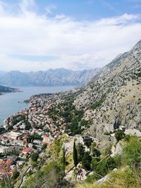 Scenic view of townscape by mountains against sky