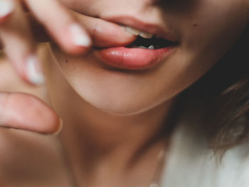 Cropped image of woman biting finger